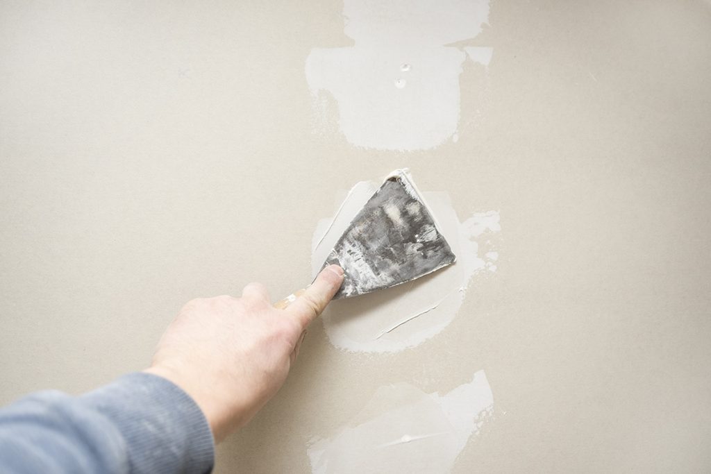 person fixing drywall