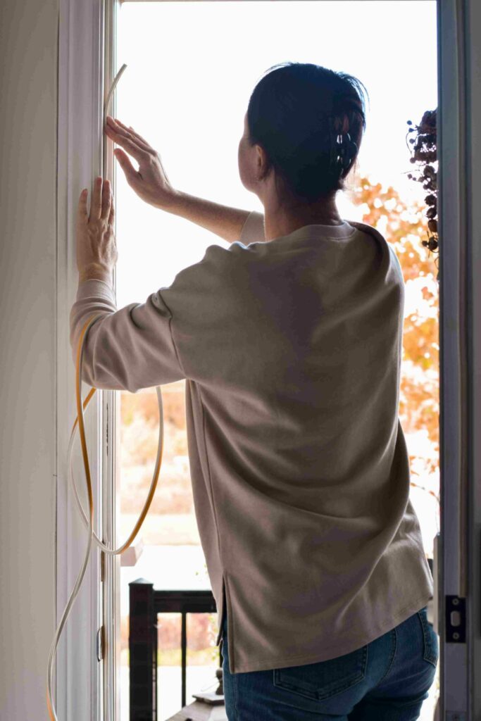 Weatherstripping being applied to a door. 